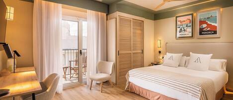 A hotel room with a bed, a desk, a chair, a ceiling fan, and a balcony with a view.