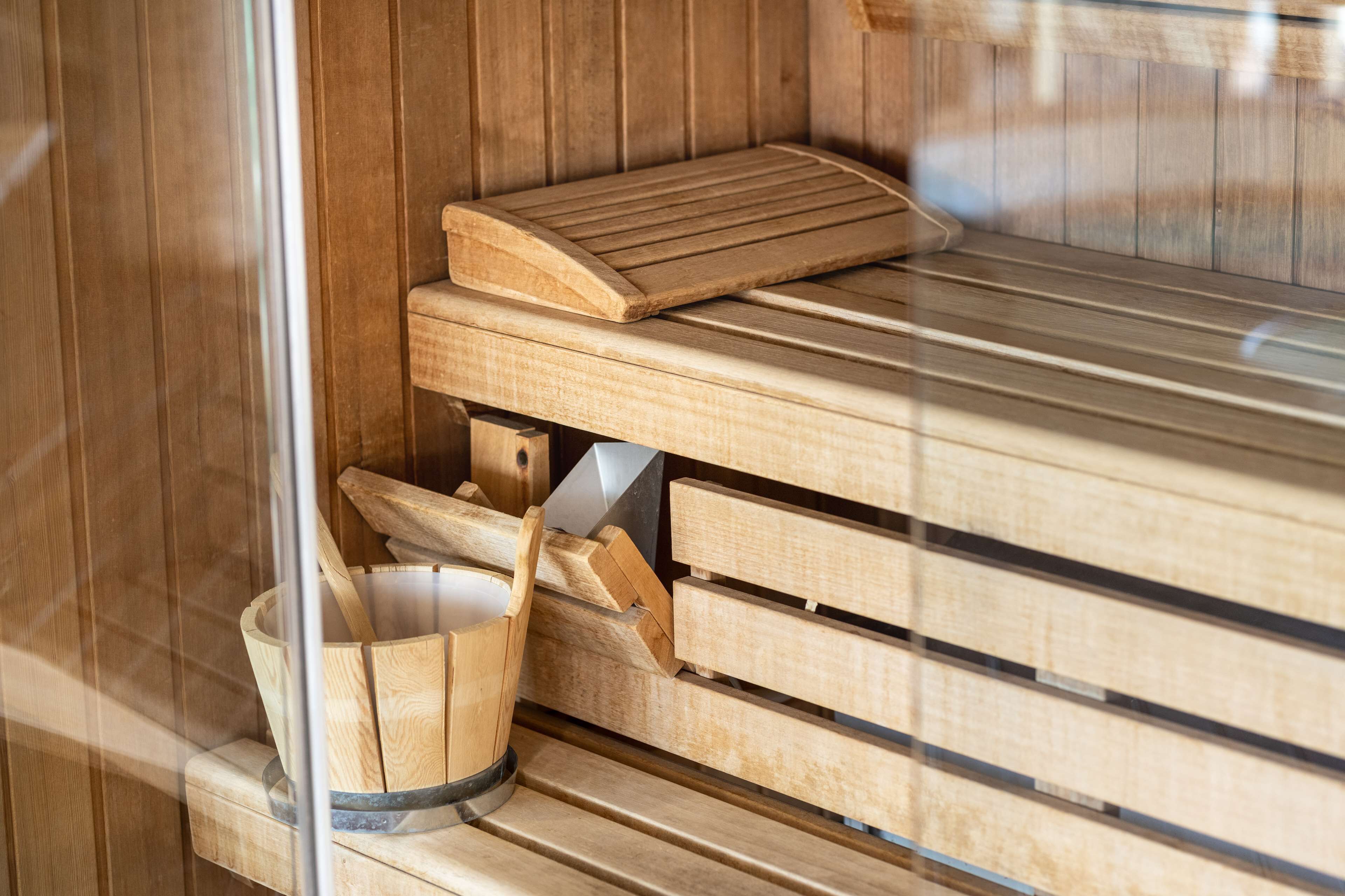 Un sauna en bois avec des bancs et un seau en bois.