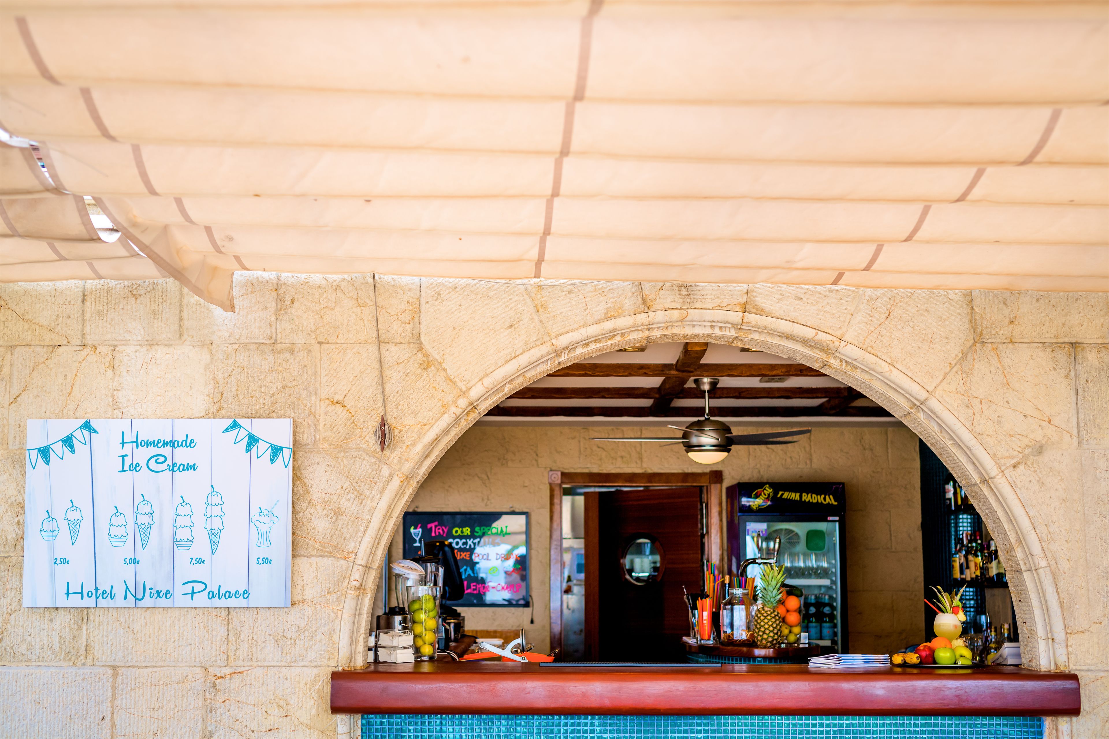 Un coin bar avec une pancarte indiquant que l’on y sert des glaces artisanales et un panneau néon faisant la publicité d’un cocktail spécial.