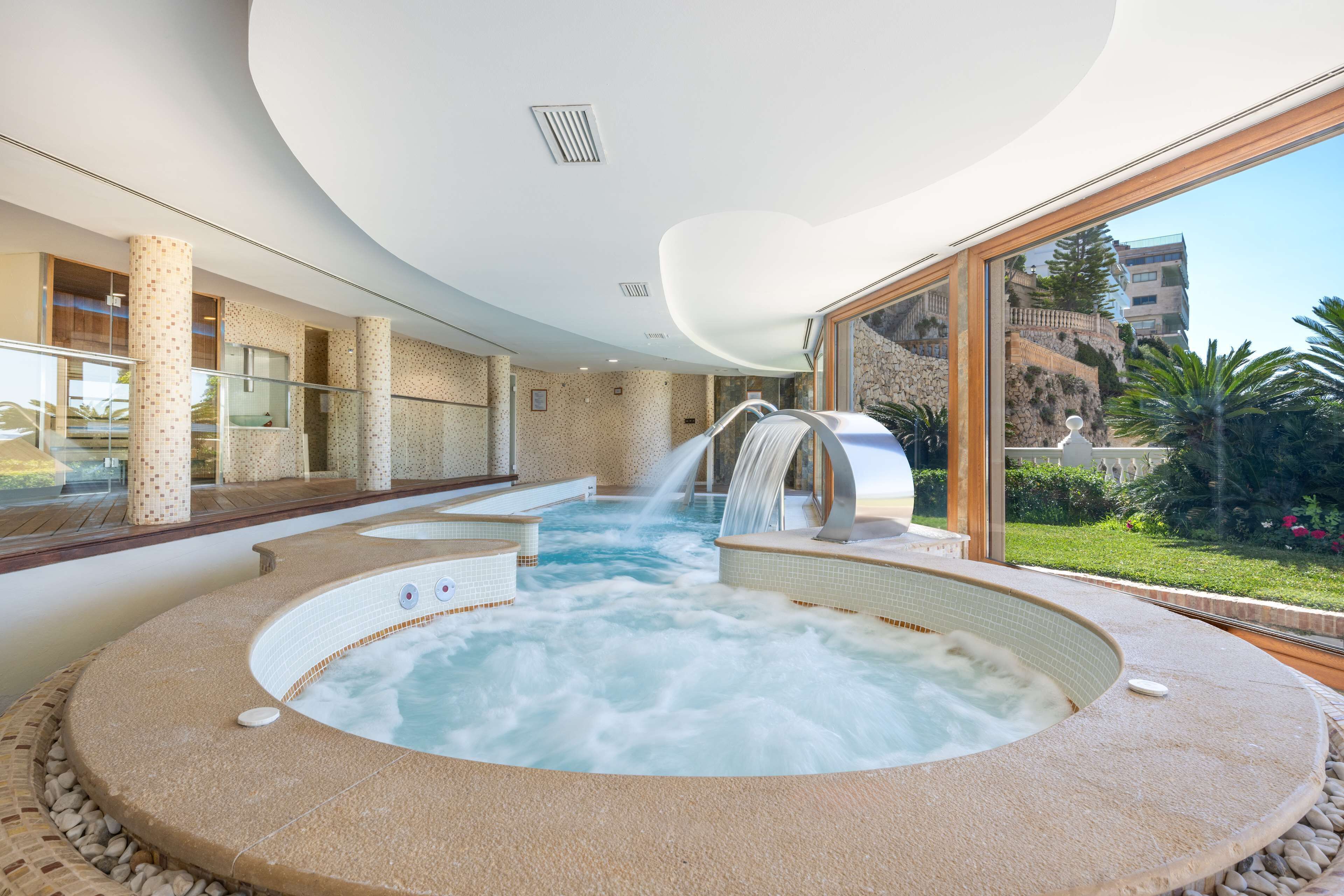 A spa area with a hot tub and a waterfall feature.