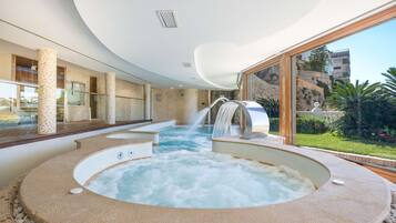 A spa area with a hot tub and a waterfall feature.