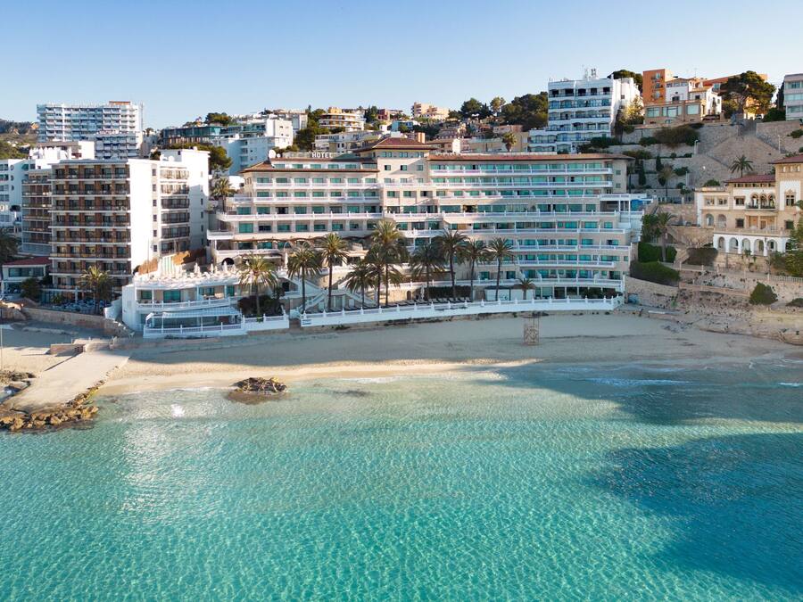 Un hotel frente al mar con varios pisos y balcones.