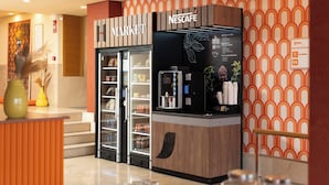 Zona de mercado Nescafé con un expositor refrigerado y una máquina de café.