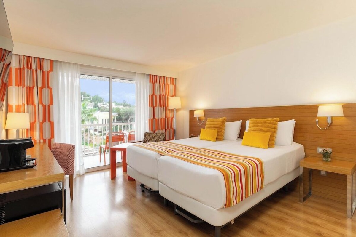 Una habitación de hotel con una cama, un escritorio y una silla.