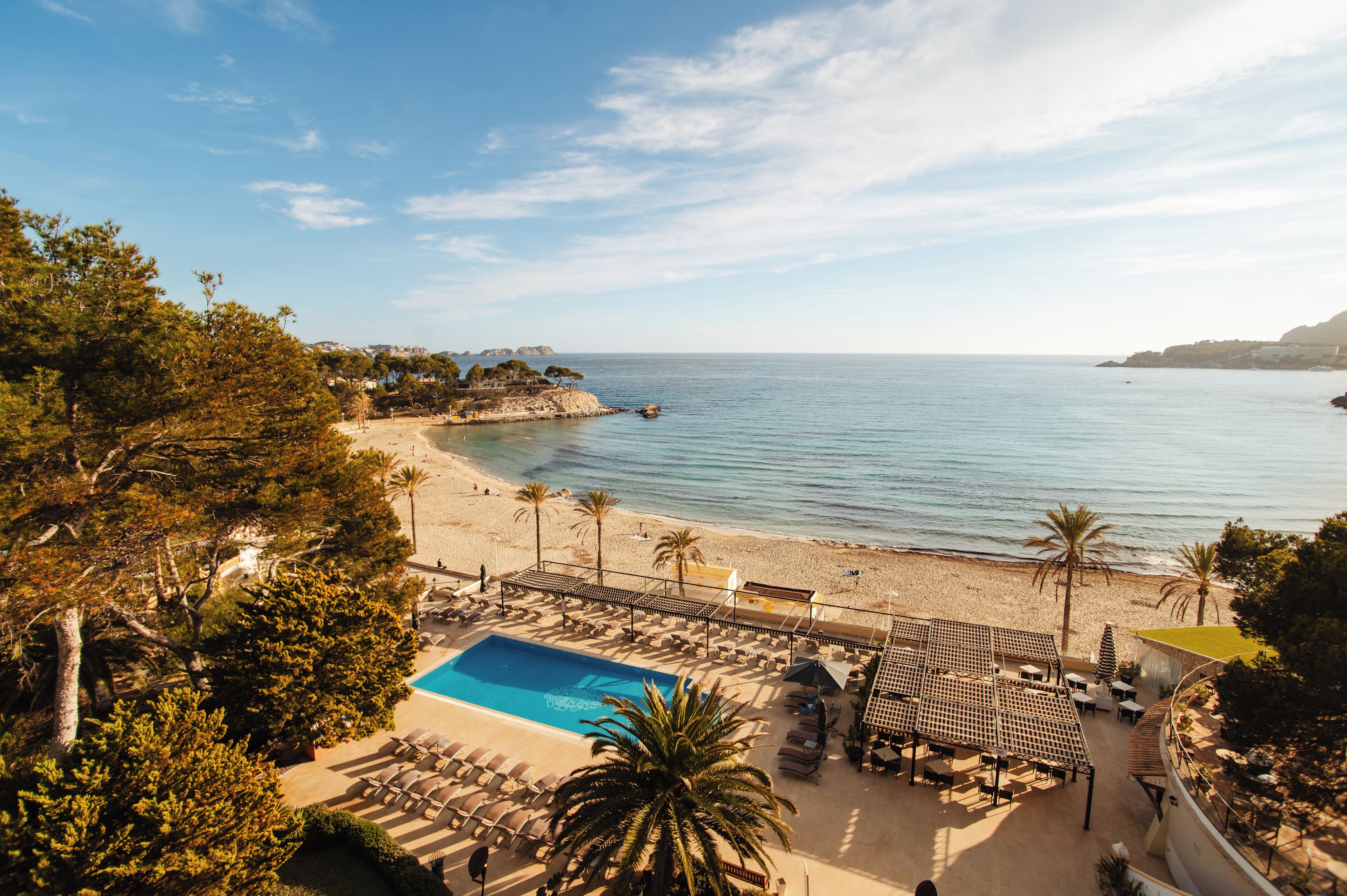 Un resort con piscina, playa y vista al océano.