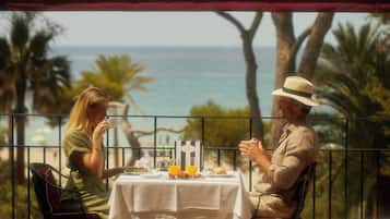 A couple dining at a table with a view of the ocean.