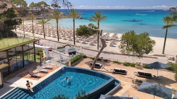 A pool area with a view of the beach and ocean.