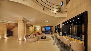 A spacious lobby with a curved sofa, seating area, and a reception desk. - Secrets Mallorca Villamil Resort & Spa - Adults Only (Calvia)