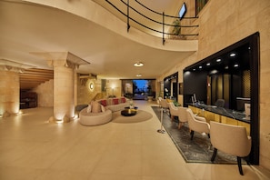 A spacious lobby with a curved sofa, seating area, and a reception desk. - Secrets Mallorca Villamil Resort & Spa - Adults Only (Calvia)