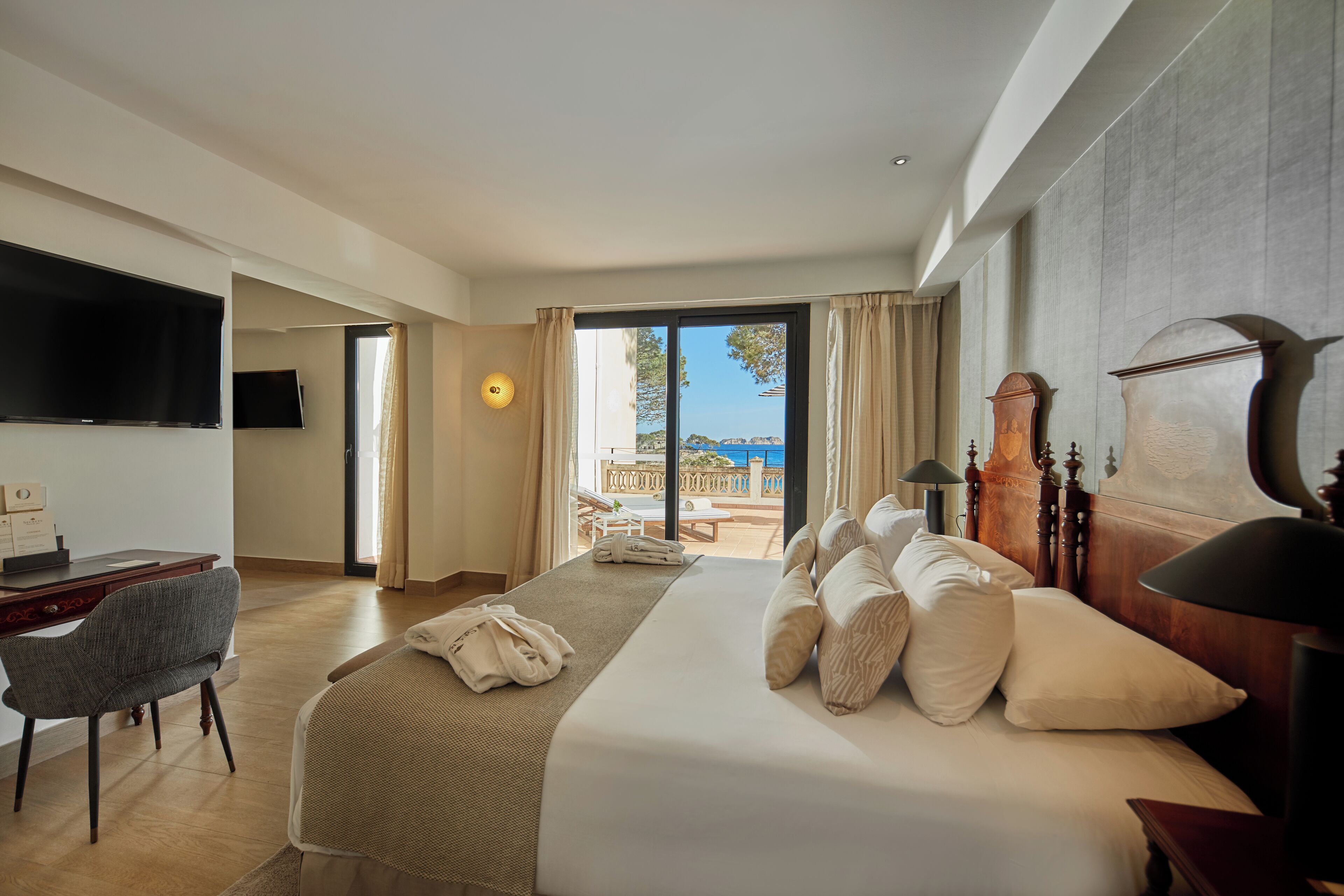 Une chambre d’hôtel avec un grand lit, un bureau, une télévision et une vue sur l’extérieur.