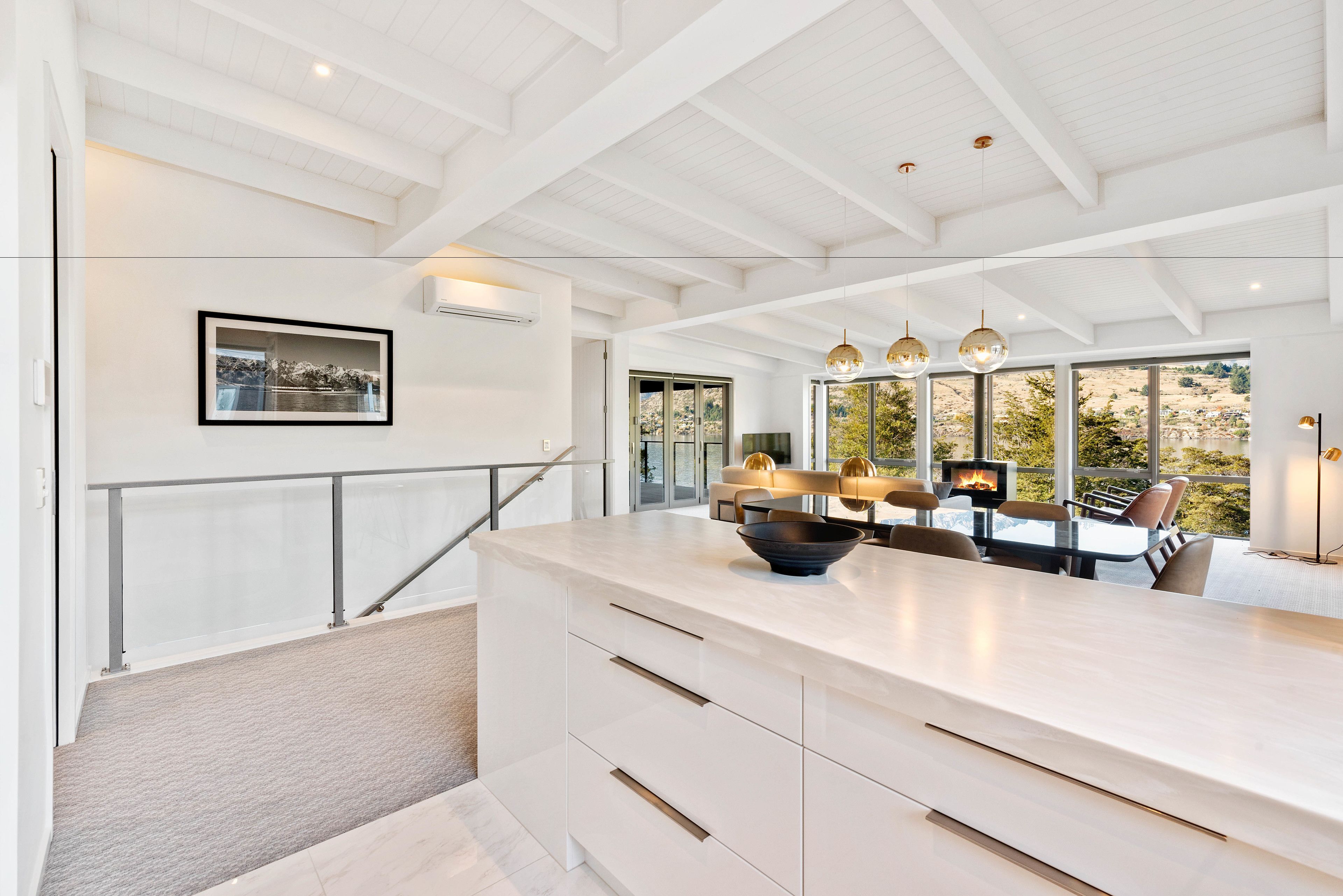 A modern kitchen with a large island, a dining area with a fire feature, and a view of the outdoors.