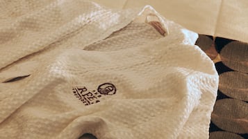 A white textured fabric with a logo and text, laid on a patterned surface.