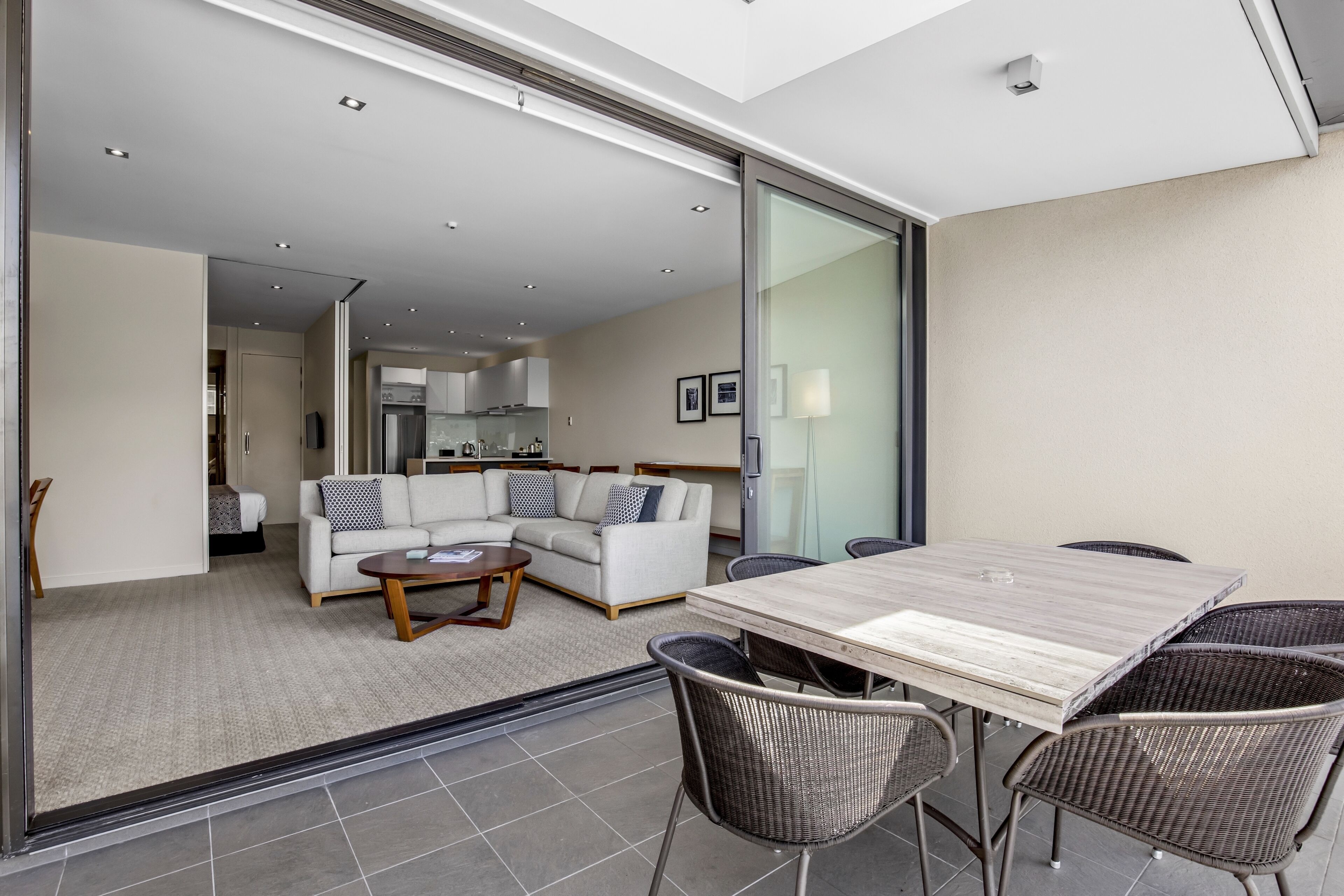 A modern living room with a sofa, coffee table, and dining table.