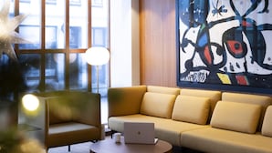 A modern living room with a sofa, a coffee table, and a laptop. - Hotel Noreg (Ålesund)