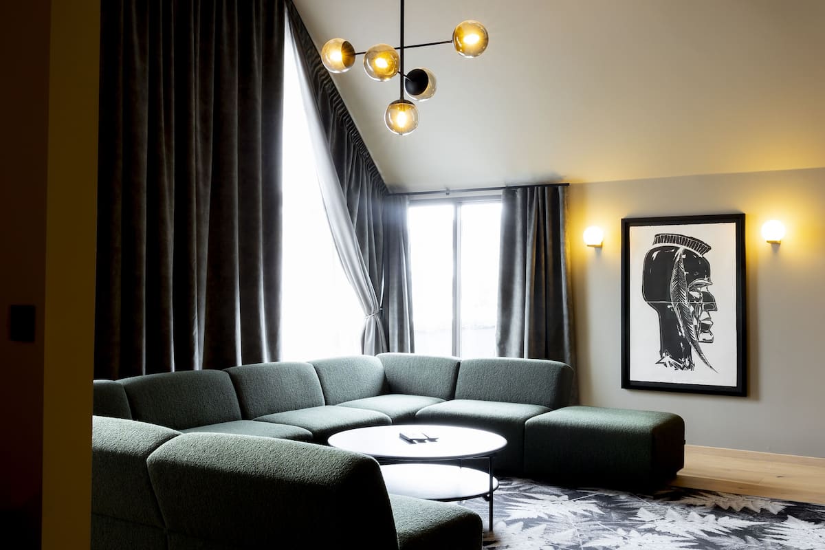 A modern living room with a sectional sofa, a round coffee table, and a patterned rug.