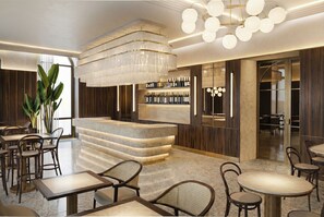 A modern bar area with a marble counter, wine bottles, and a chandelier. - Slavia (Brno)