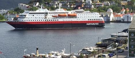 Un gran crucero amarrado en un puerto con un pueblo al fondo.