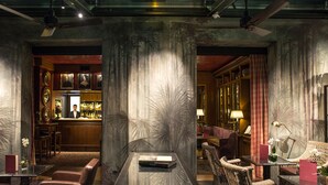 A bar area with a bartender, a bar counter, and a seating area with chairs and a table.