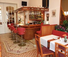 A bar area with stools, a counter, and a seating area with tables and chairs.
