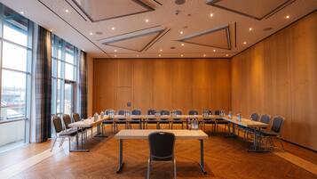 Une salle de conférence dotée d’une longue table, de chaises et offrant une vue sur la ville grâce à de grandes fenêtres.