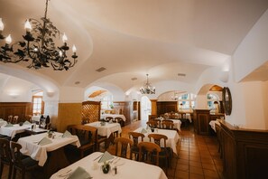 A restaurant with multiple tables, chairs, and chandeliers. - Hotel Bayerischer Hof Miesbach, BW Premier Collection (Miesbach)