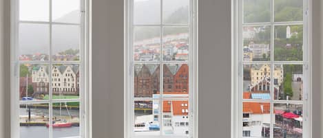 Three windows with a view of a town, including buildings and a body of water.