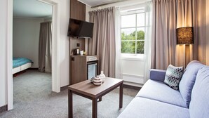 A hotel room with a bed, a TV, a coffee machine, a table, and a sofa. - Scandic Leknes Lofoten (Vestvågøy)