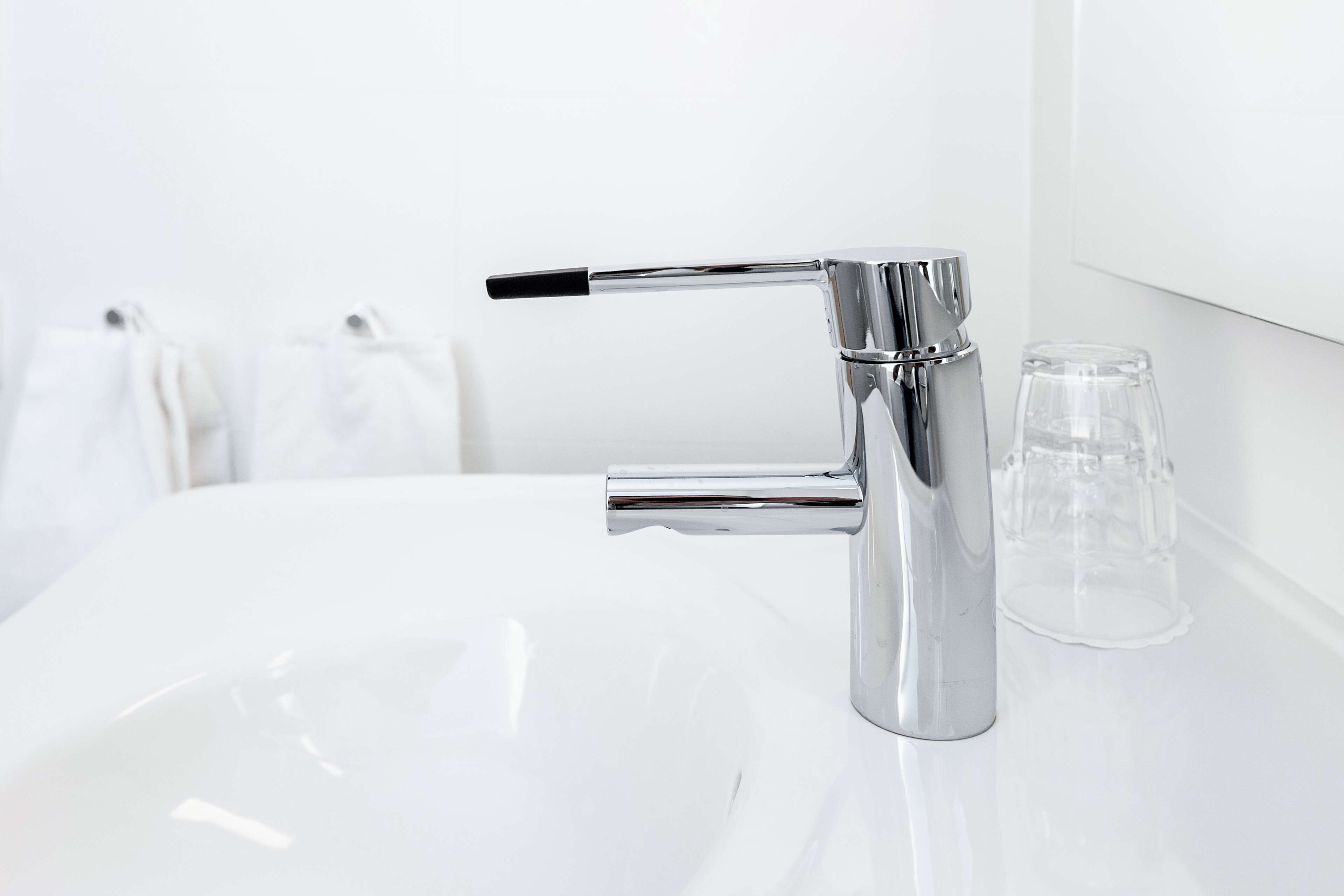 Un bagno moderno con un rubinetto cromato e un lavandino bianco.