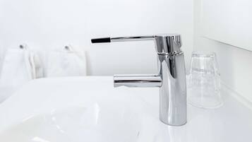 Un bagno moderno con un rubinetto cromato e un lavandino bianco.