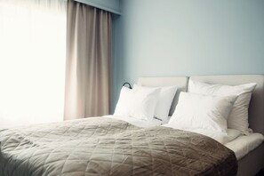 Relax in a spacious room with a large bed and modern headboard.