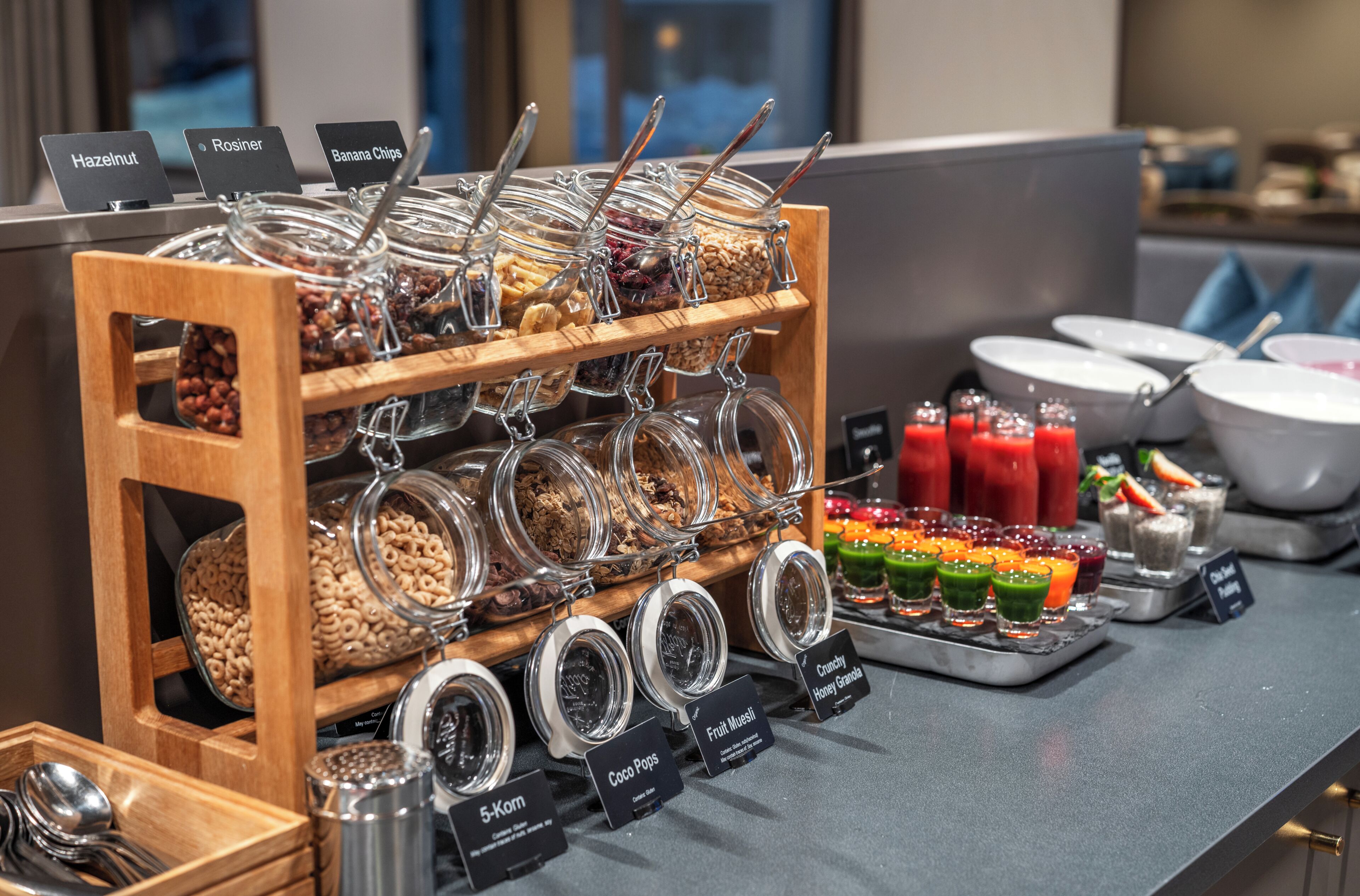 A breakfast buffet with labeled food options and a variety of beverages.