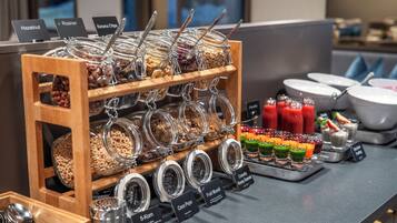 A breakfast buffet with labeled food options and a variety of beverages.