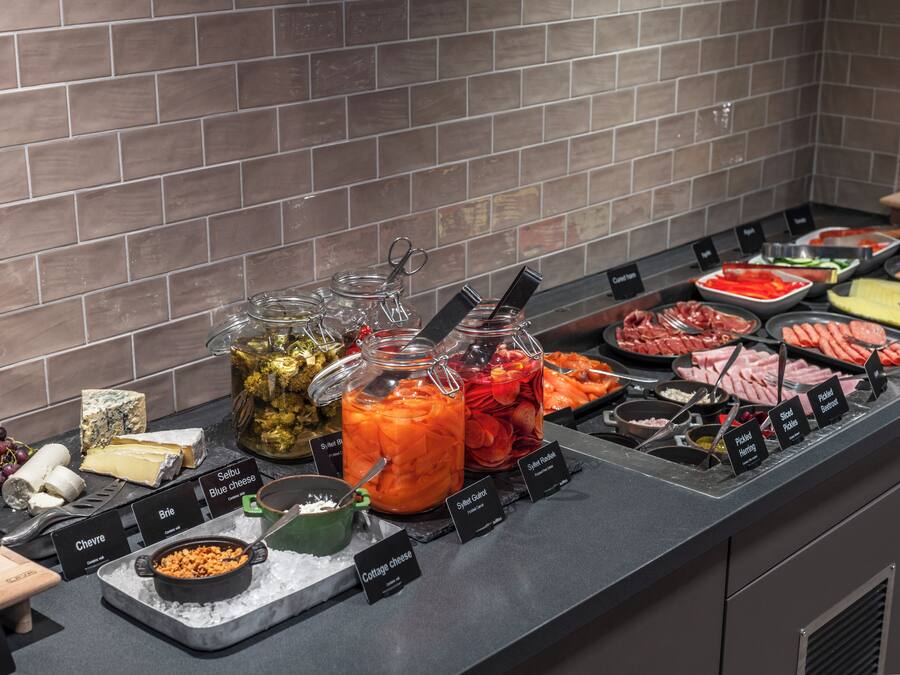 A buffet with various food options including cheese, meats, and fruits.