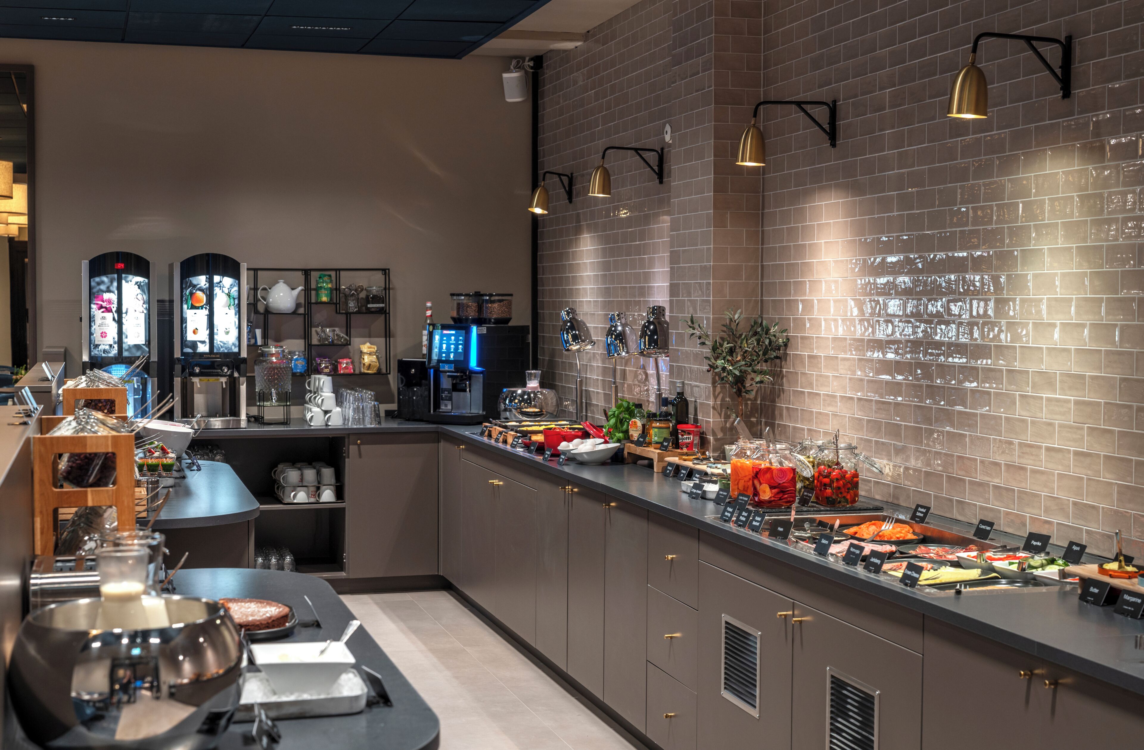 Montaje de bufé con diferentes opciones de comida, una máquina de café y una estación de té.