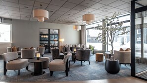 A modern hotel lobby with seating, a large window, and a potted plant. - Thon Hotel Andrikken (Andoy)