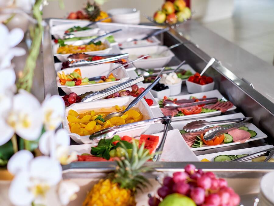 A buffet with various food options and utensils.