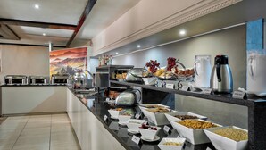 Uma área de buffet com diversas opções de comida e bebidas.