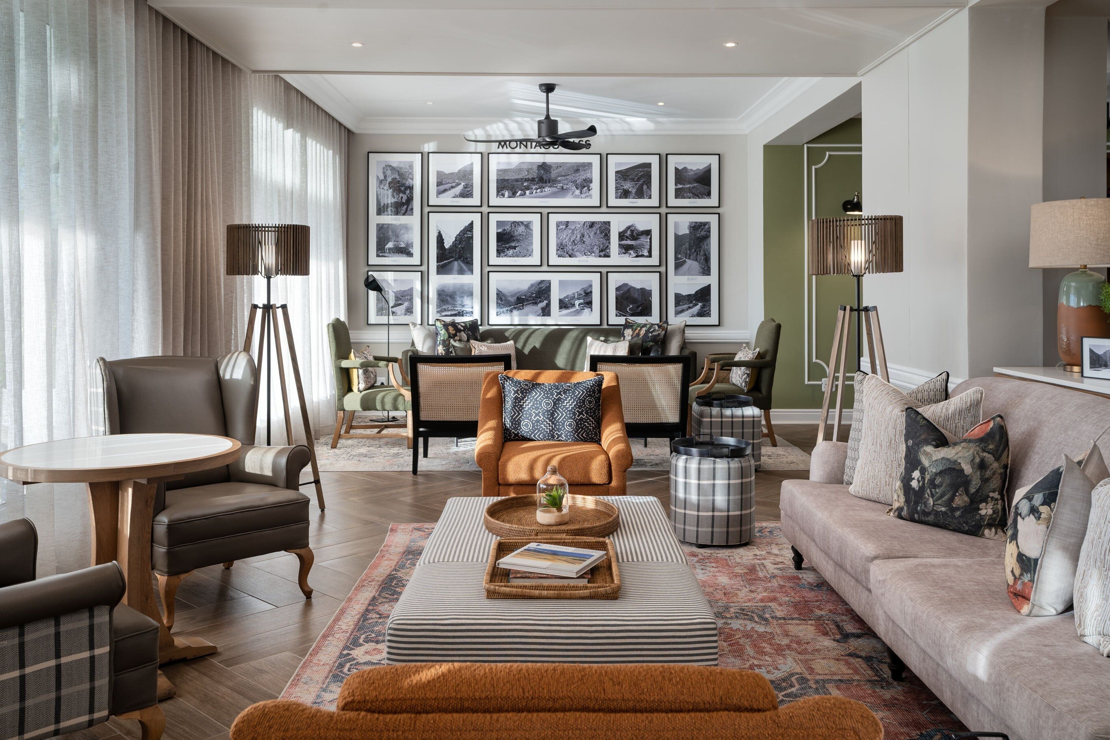 Een moderne woonkamer met een bank, fauteuils, een salontafel en een eethoek.