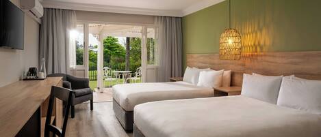 A hotel room with two beds, a desk, a chair, a TV, and a large window with curtains.