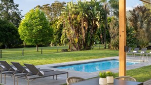 A pool area with lounge chairs, a table, and potted plants. - Protea Hotel by Marriott George King George (George)