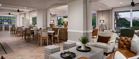 A spacious living area with a dining set, comfortable seating, and a view of the outdoors.
