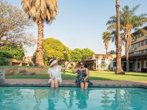 Una piscina al aire libre, sillones reclinables de piscina