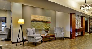 A lobby with two grey armchairs, a floor lamp, a table with a vase, and a large abstract painting on the wall. - ANEW Hotel Witbank Emalahleni (Emalahleni)
