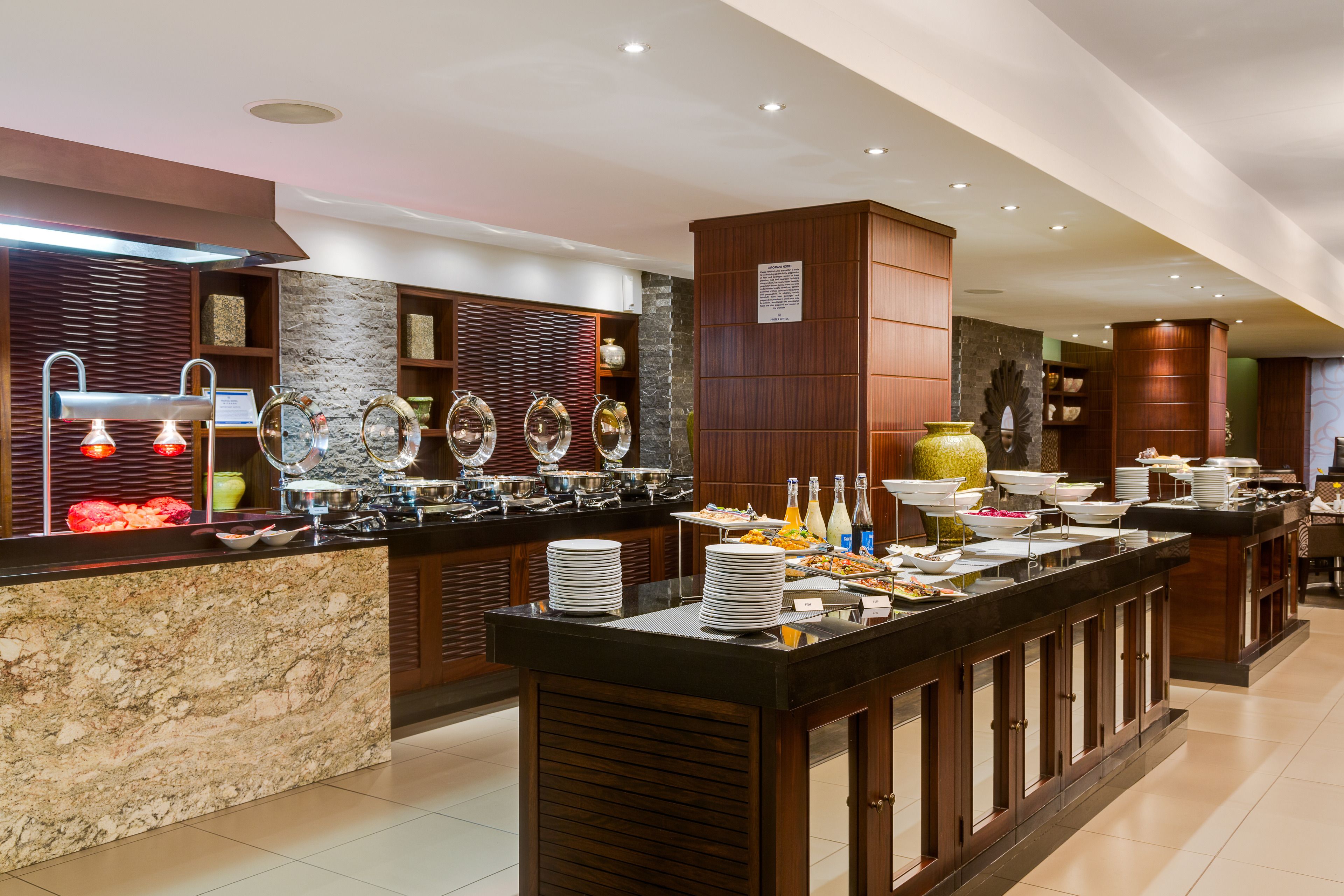A buffet setup with multiple serving stations, a variety of dishes, and a modern interior design.