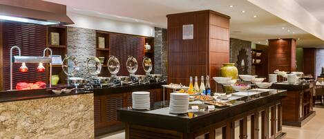 A buffet setup with multiple serving stations, a variety of dishes, and a modern interior design.