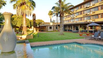 Een buitenzwembad en ligstoelen