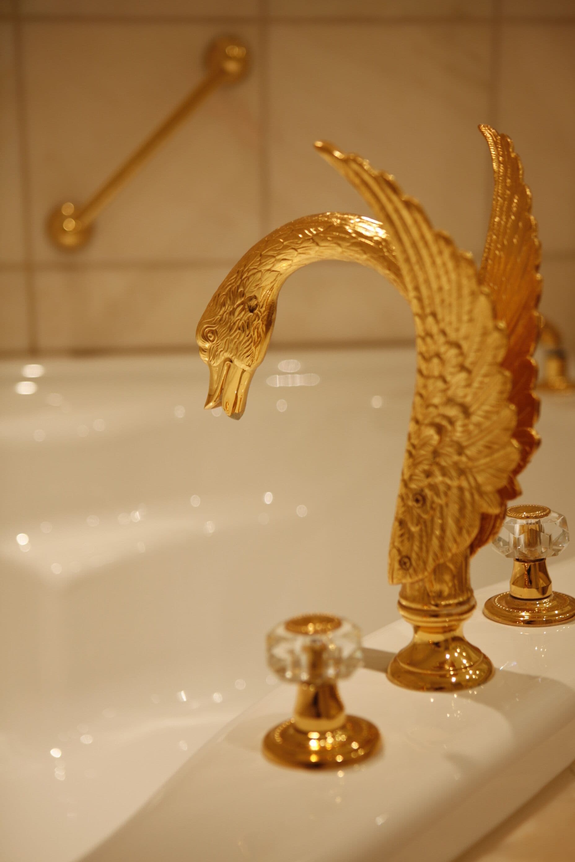 Ein Badezimmer mit einer goldenen Wasserhahn und einem goldenen Handtuchhalter.