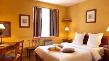 A hotel room with a large bed, two bedside tables, a chair, a desk, and a window with curtains.