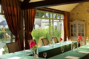 Enjoy meals in this elegant dining area with a long table, wine glasses, and beautiful vases.