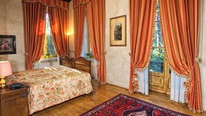 A bedroom with a wooden bed, a nightstand, a lamp, and a framed picture on the wall.